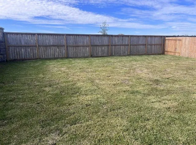 a view of a backyard with a fence