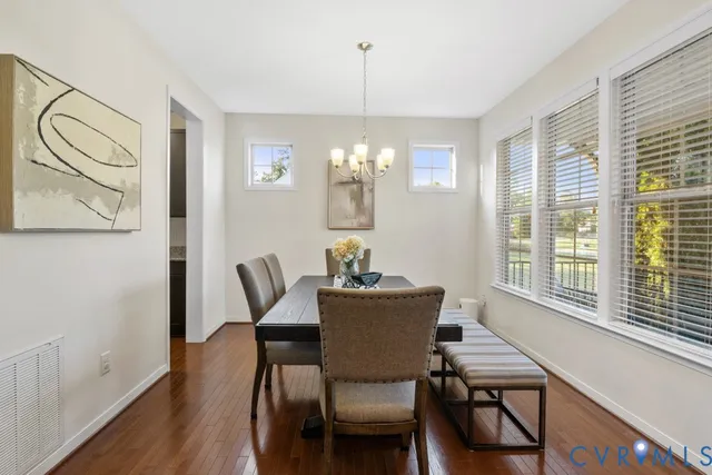 a dining room with furniture a chandelier and wooden floor