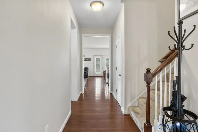 a view of a hallway with wooden floor and staircase