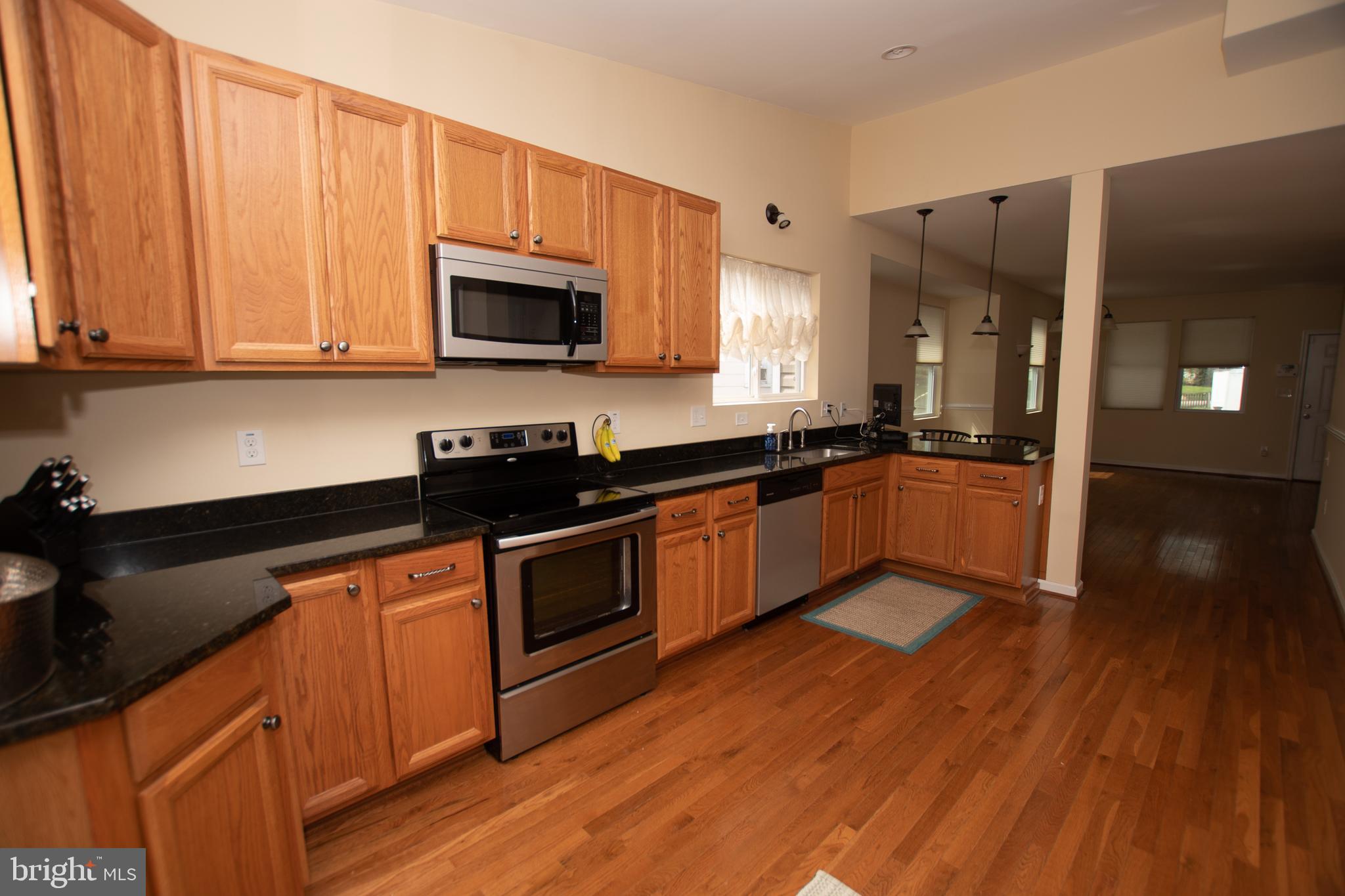 67 Edmondson Ridge Road Baltimore, MD 21228 - Photo 4 of 41 a kitchen with granite countertop stainless steel appliances and wooden cabinets