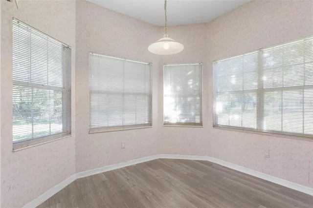 a view of a hallway with wooden floor and a living room