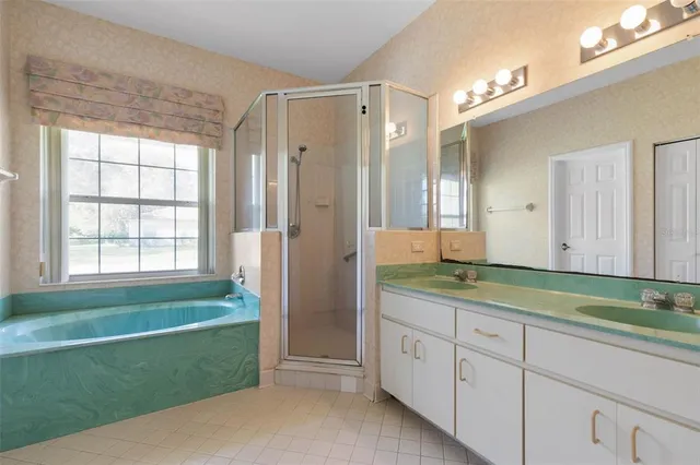 a spacious bathroom with a granite countertop sink a mirror and a shower