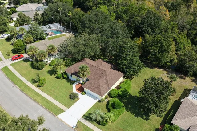 an aerial view of residential houses with outdoor space and trees