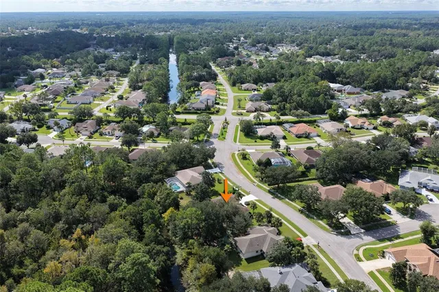 an aerial view of residential houses with outdoor space and trees