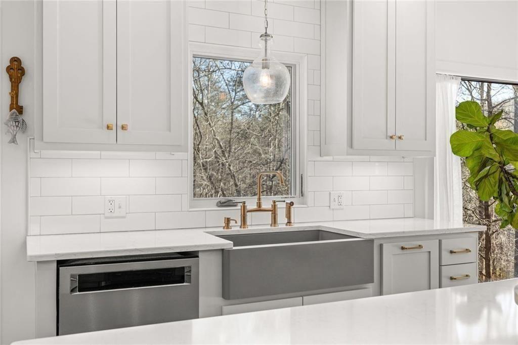 3680 Lamplighters Cove Road Gainesville, GA 30504 - Photo 22 of 88 a kitchen with granite countertop a sink and a white wooden cabinets