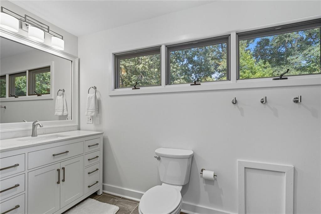 3680 Lamplighters Cove Road Gainesville, GA 30504 - Photo 39 of 88 a bathroom with a toilet sink a window and mirror