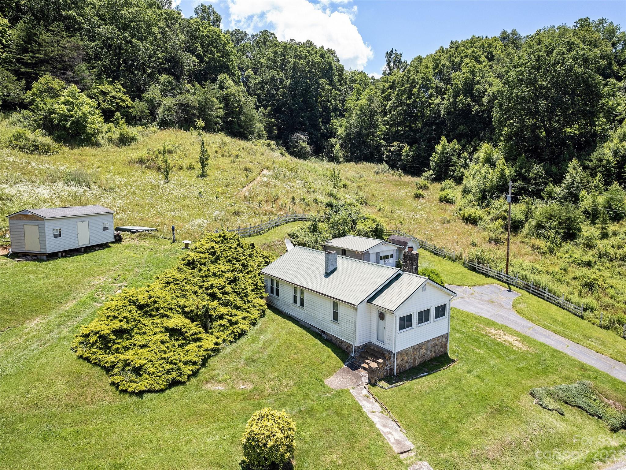2656 Hyder Mountain Road Clyde, NC 28721 - Photo 2 of 21 a white house with a yard and sitting area