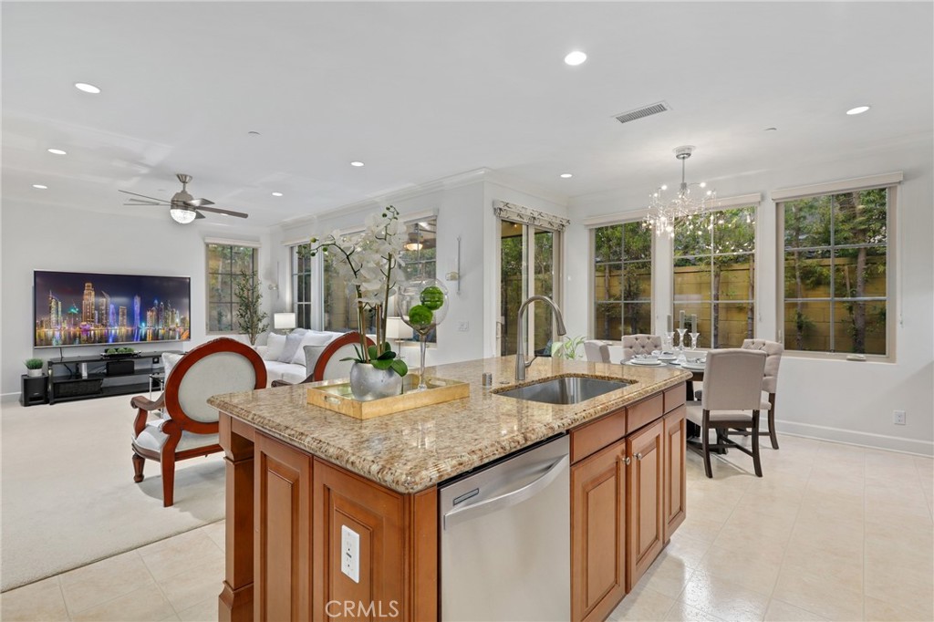 72 Brindisi Irvine, CA 92618 - Photo 14 of 48 a dining hall with stainless steel appliances granite countertop a table and chairs with wooden floor