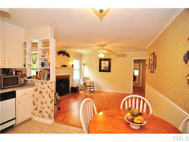 5531 McCormick Road Durham, NC 27713 - Photo 5 of 15 a living room with furniture a fireplace and a kitchen view