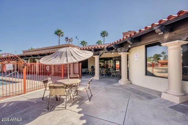 a view of a patio with a table and chairs under an umbrella