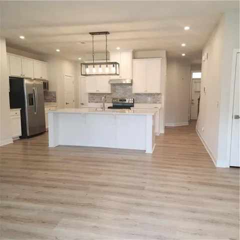 a kitchen with stainless steel appliances a refrigerator and a stove top oven