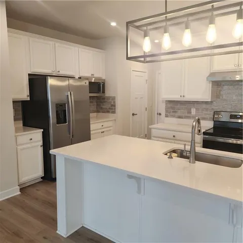 a kitchen with a sink and chandelier