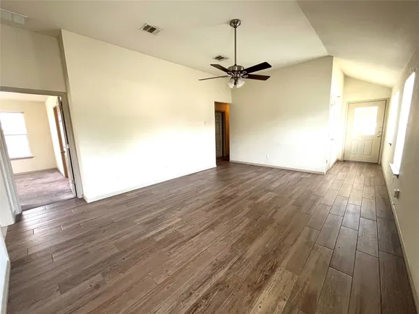 a view of empty room with wooden floor