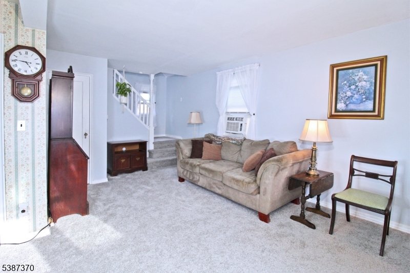 126 Baker Street Dover, NJ 07801 - Photo 4 of 11 a living room with furniture a clock on wall and a window