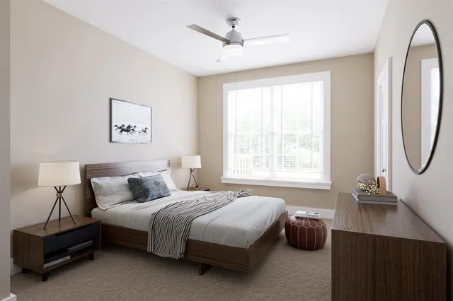 a bedroom with a bed a mirror and a large window