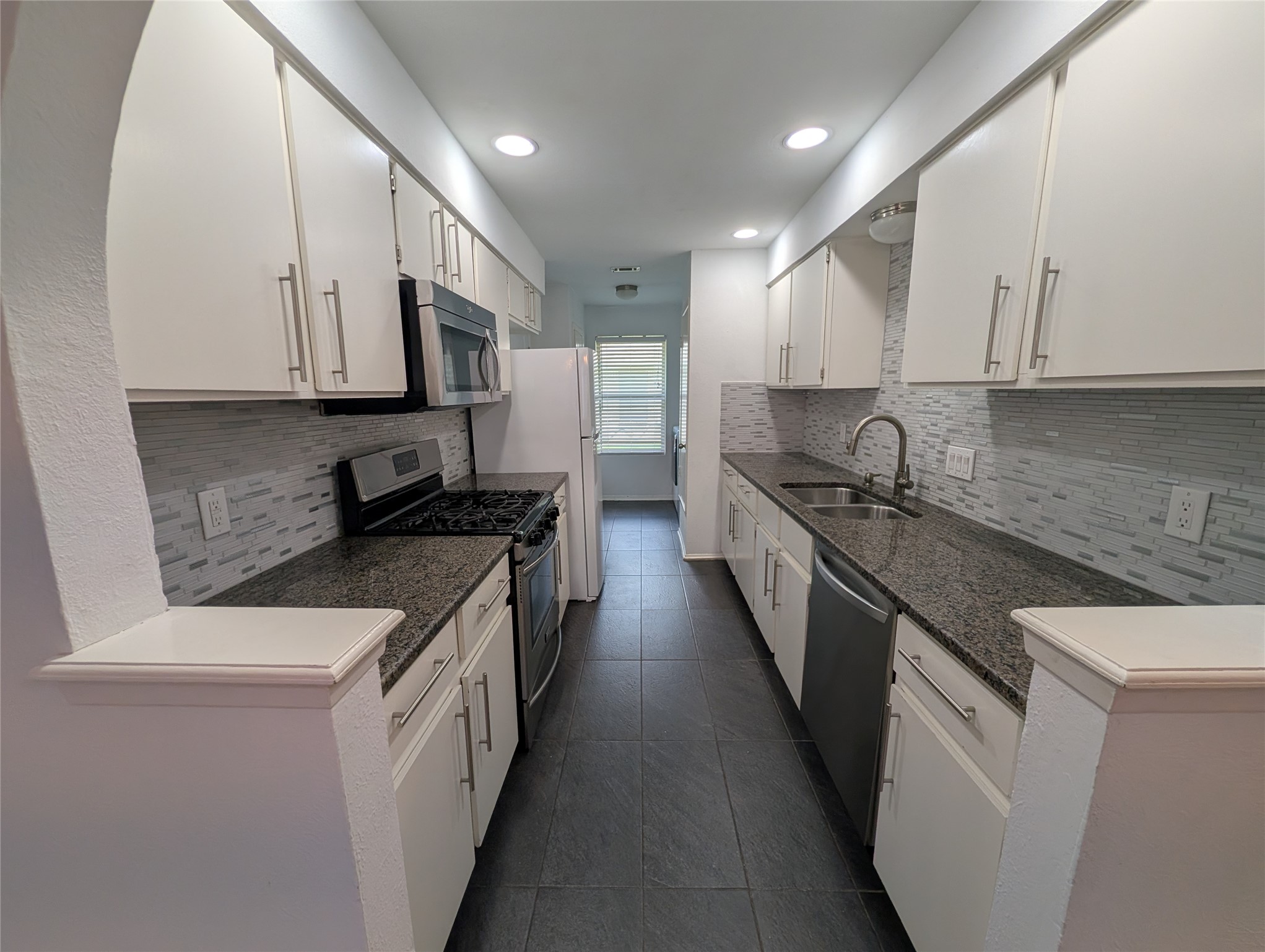 4601 Tamarack Trail Austin, TX 78727 - Photo 9 of 19 Culinary adventures await in this streamlined kitchen with stone counters and contemporary backsplash.