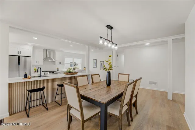 a view of a dining room and a kitchen with a table chairs