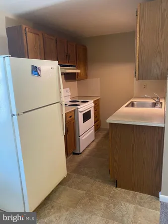 a white refrigerator freezer and a stove sitting inside of a kitchen
