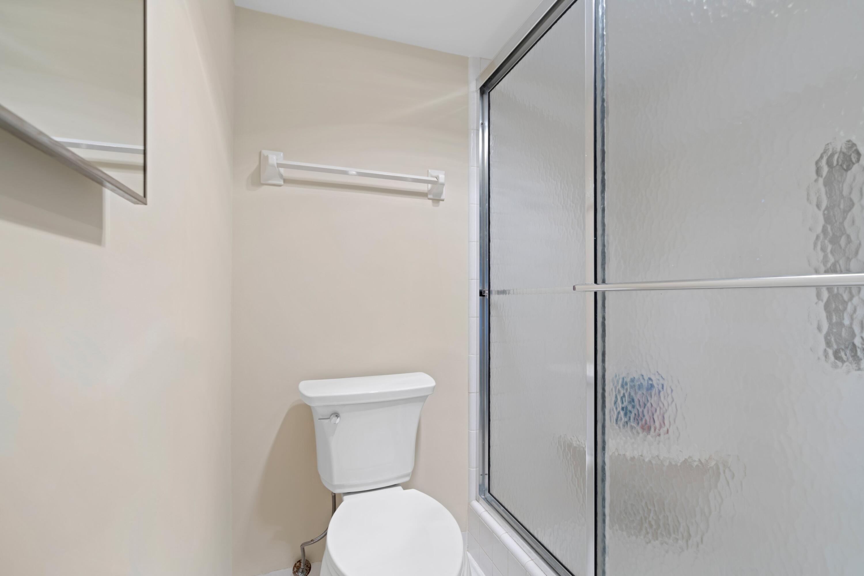 2301 Northeast 36th Street, Unit 204 Lighthouse Point, FL 33064 - Photo 11 of 20 a white toilet sitting next to a shower