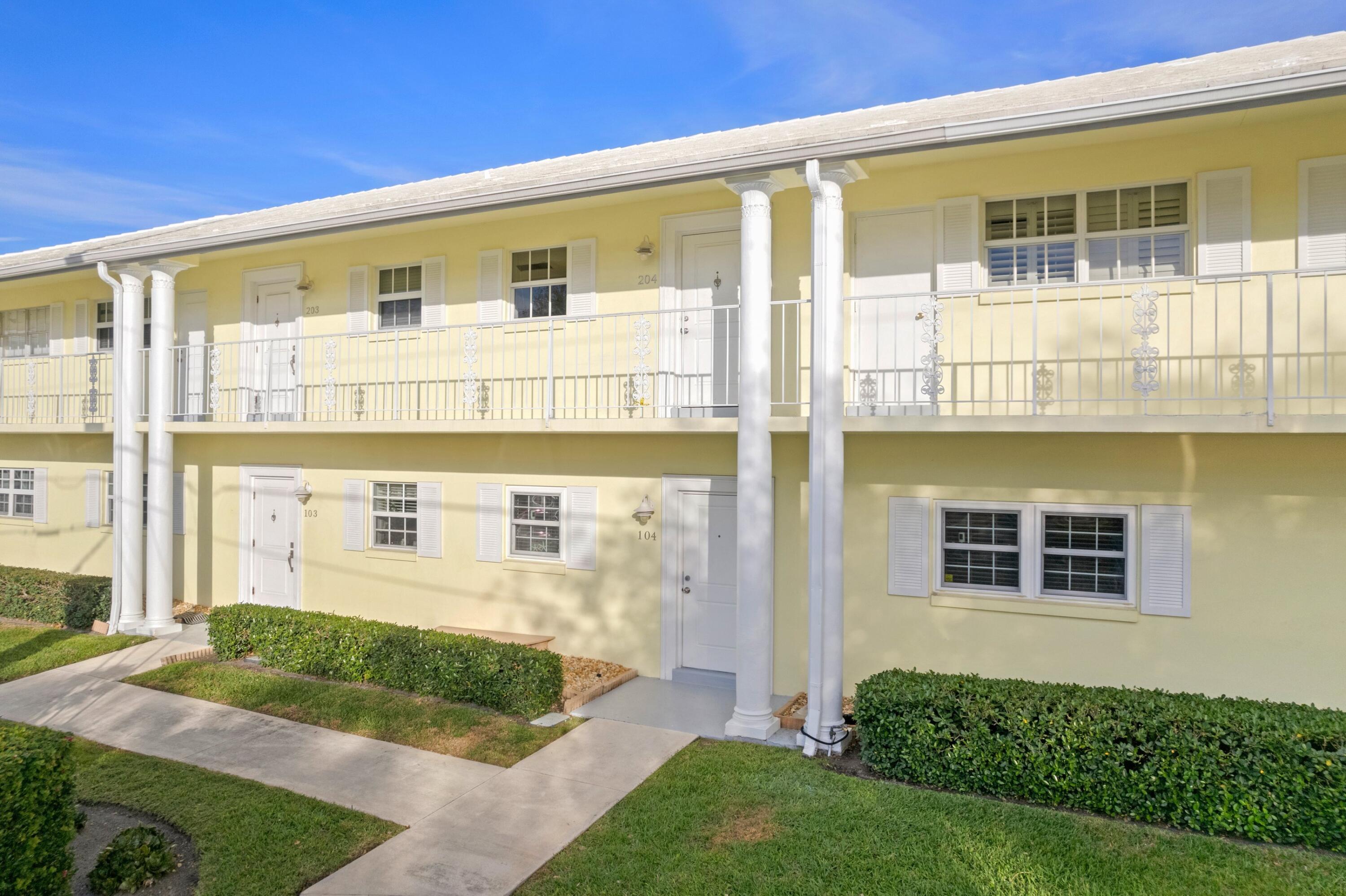 2301 Northeast 36th Street, Unit 204 Lighthouse Point, FL 33064 - Photo 14 of 20 a front view of a house with a yard