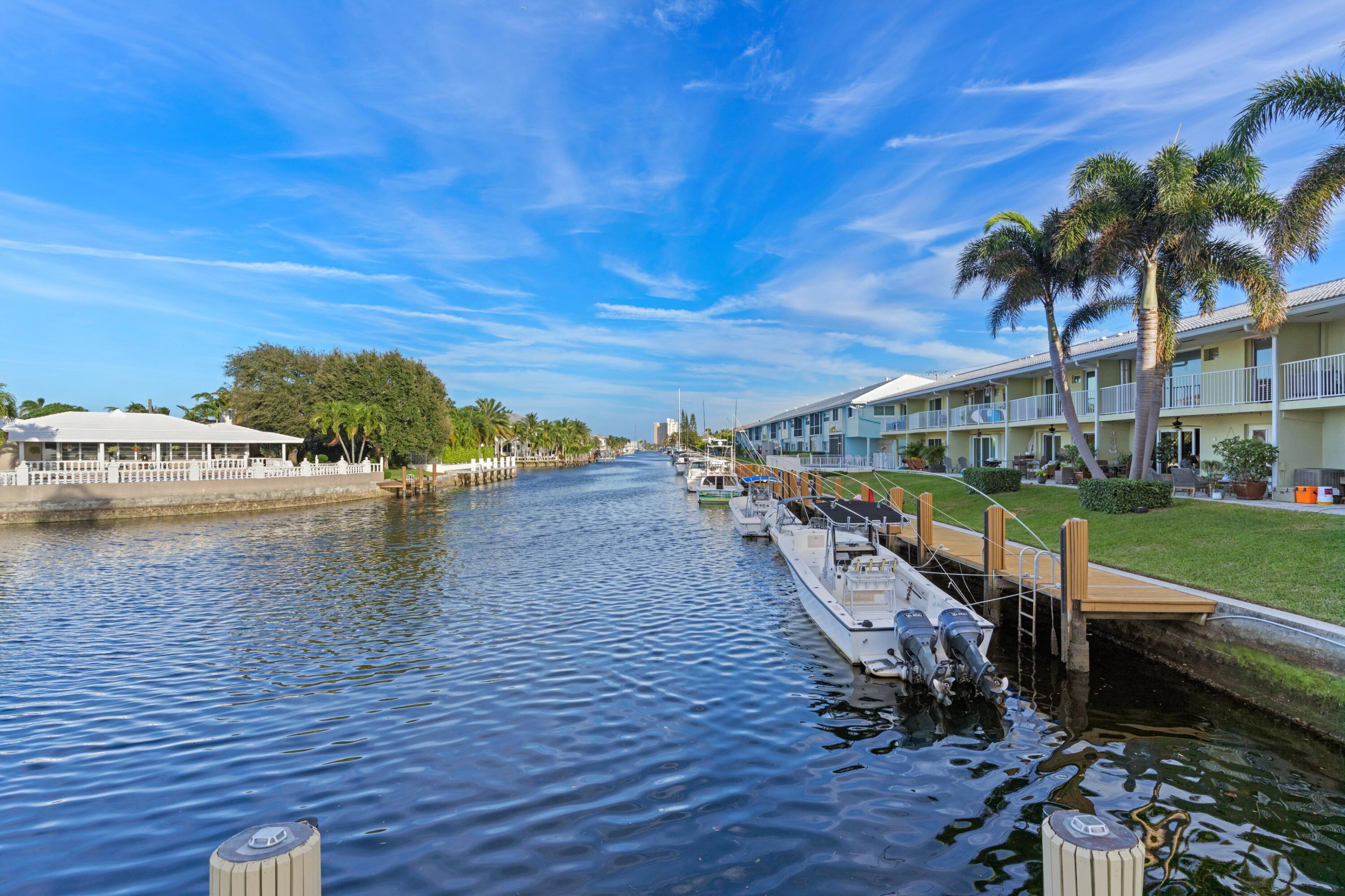 2301 Northeast 36th Street, Unit 204 Lighthouse Point, FL 33064 - Photo 16 of 20 a view of a swimming pool with a lawn chairs under an umbrella