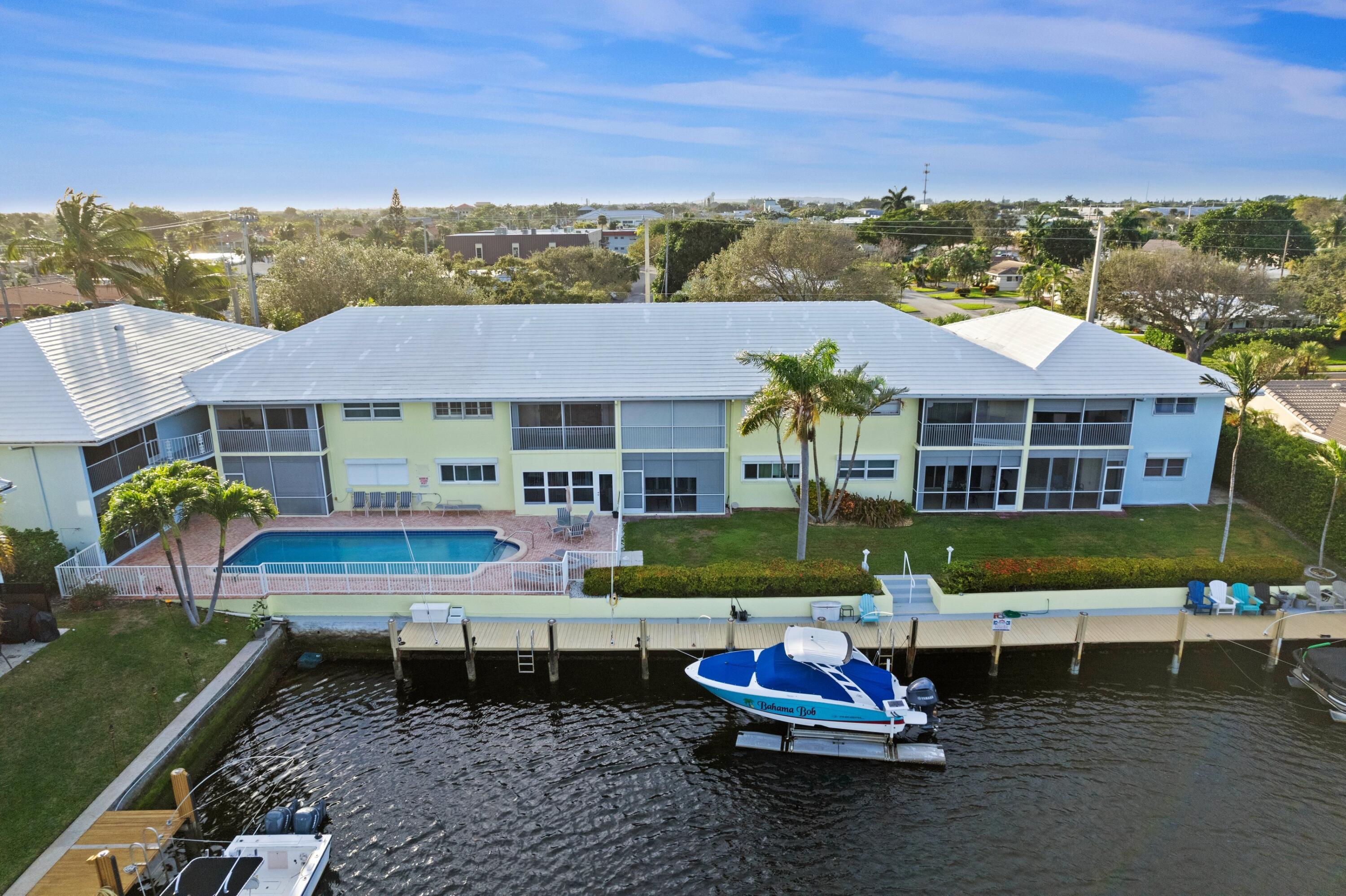 2301 Northeast 36th Street, Unit 204 Lighthouse Point, FL 33064 - Photo 2 of 20 a front view of house with a garden and patio
