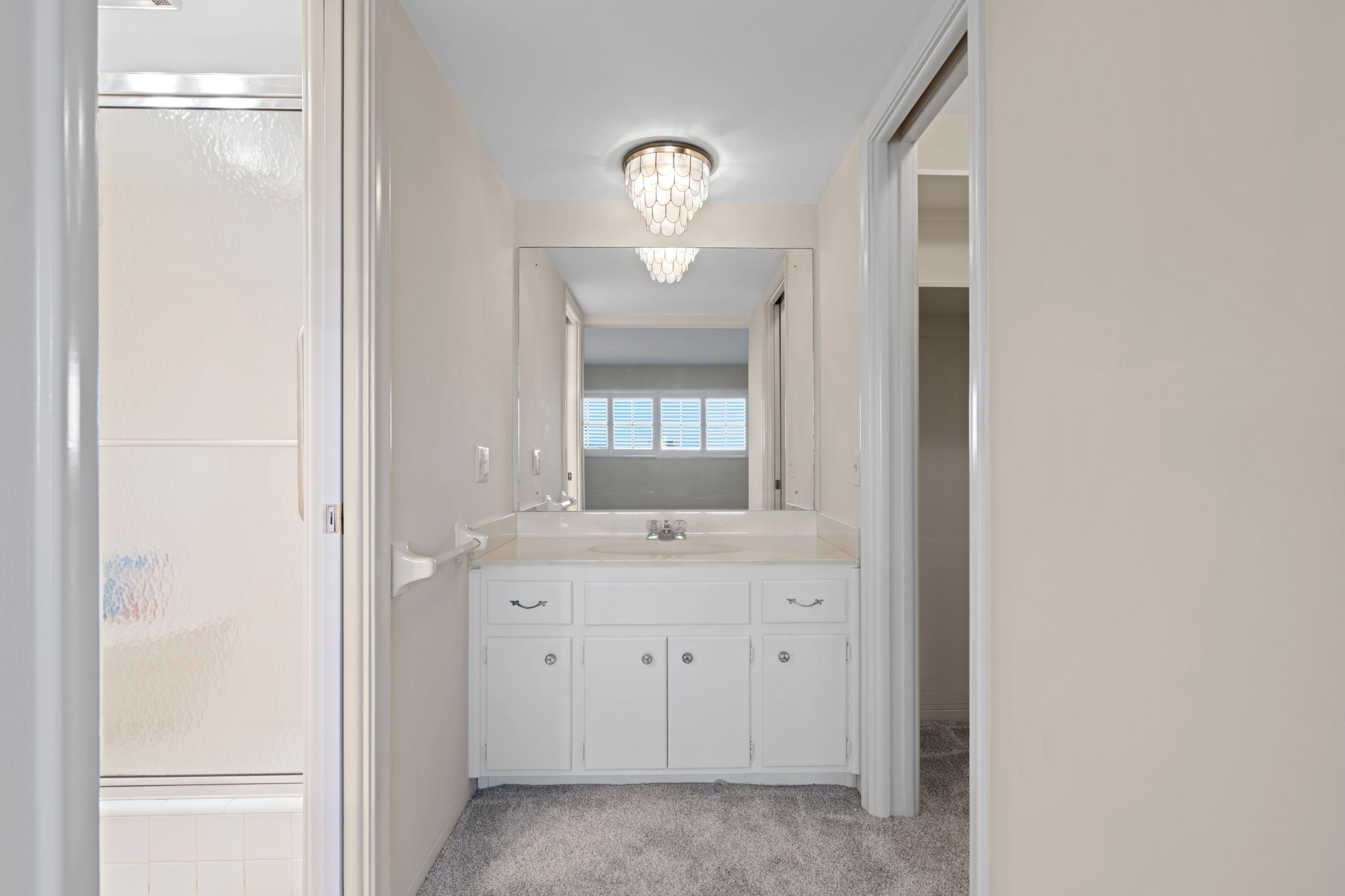 2301 Northeast 36th Street, Unit 204 Lighthouse Point, FL 33064 - Photo 10 of 20 a bathroom with a light fixture and a mirror