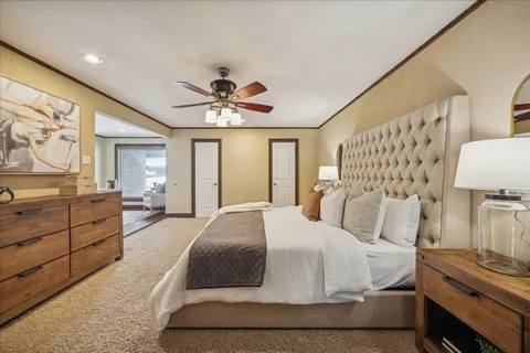 a spacious bedroom with a bed and dresser with mirror