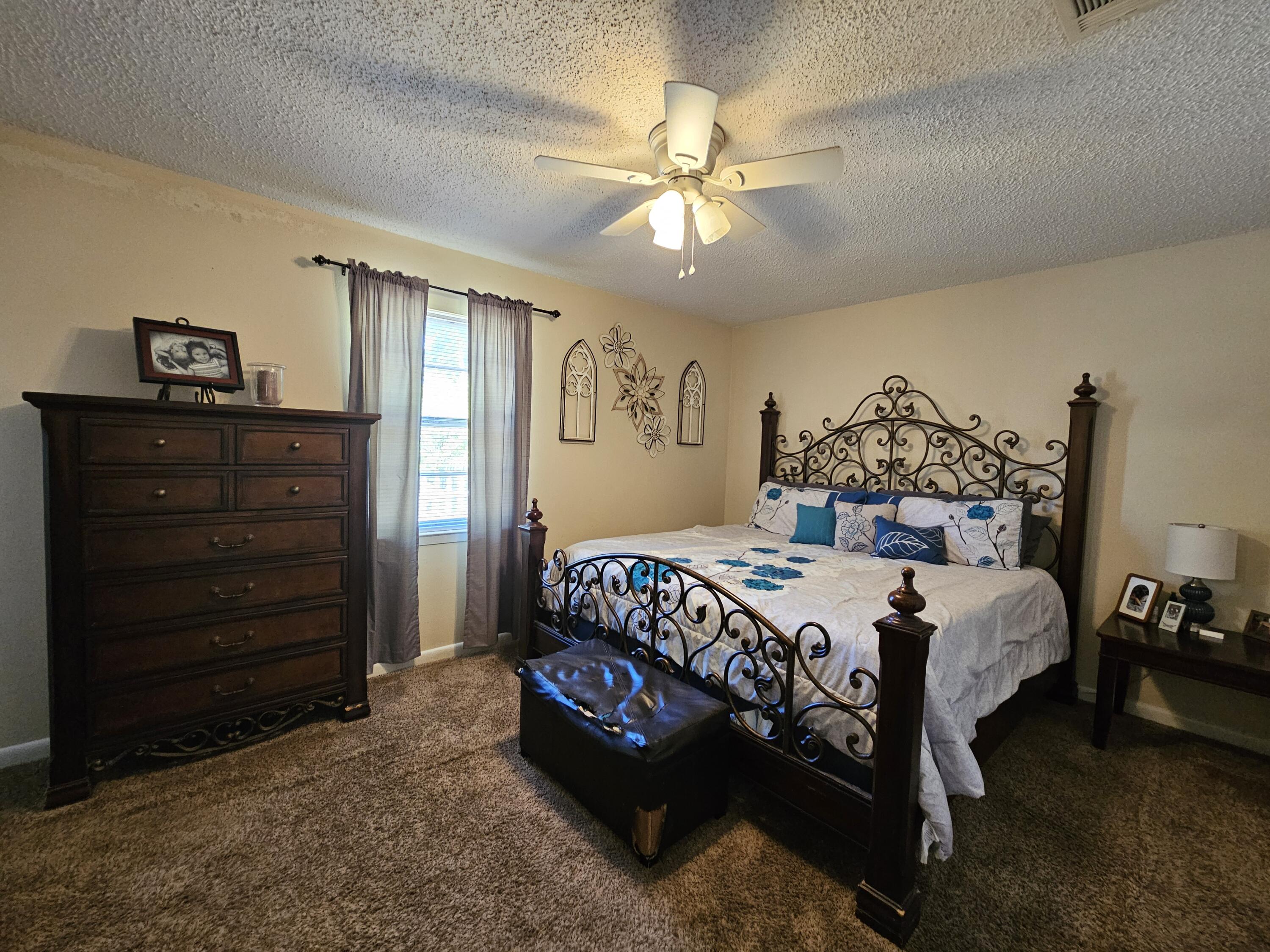 4017 Bear Creek Road Crestview, FL 32539 - Photo 14 of 28 a bedroom with a bed and a chandelier