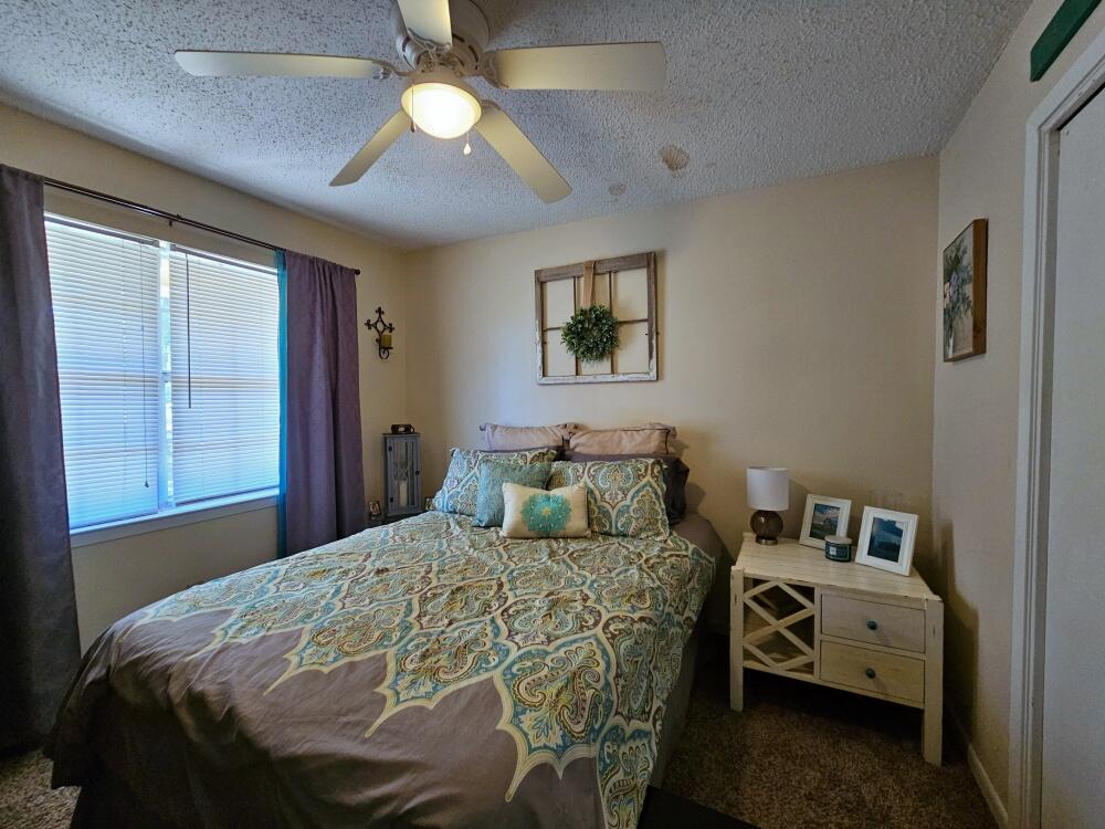 4017 Bear Creek Road Crestview, FL 32539 - Photo 17 of 28 a bedroom with a bed and a chandelier