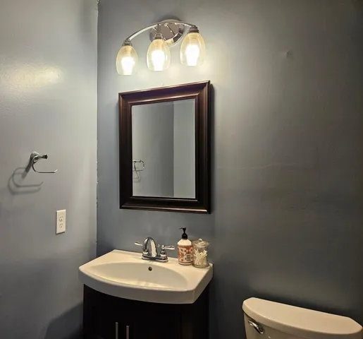 a bathroom with a toilet sink and mirror