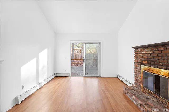 an empty room with wooden floor and fireplace