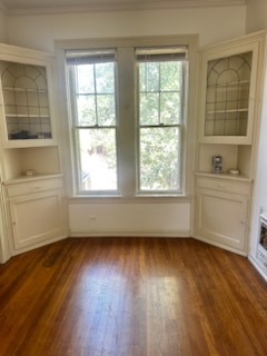 1519 Enfield Road Austin, TX 78703 - Photo 2 of 18 Charming built-in corner cabinets flank bright double-hung windows over rich hardwood flooring.