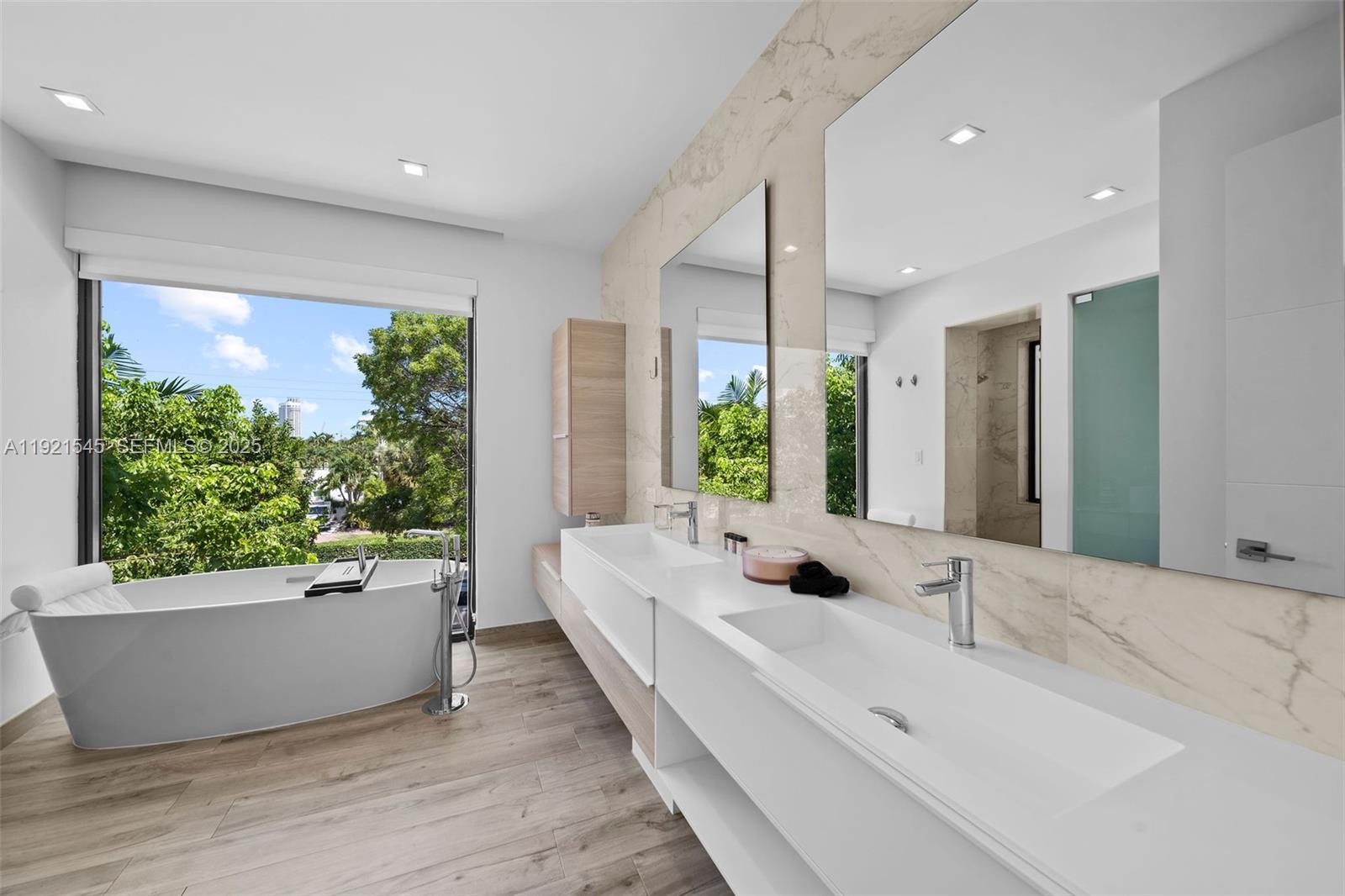 4740 Alton Road Miami Beach, FL 33140 - Photo 16 of 34 a bathroom with a large tub and sink