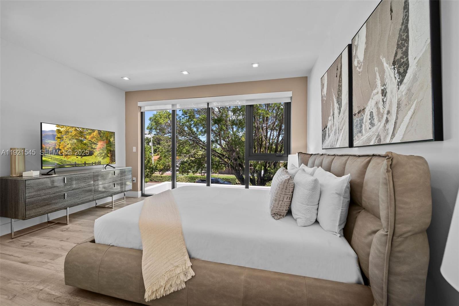 4740 Alton Road Miami Beach, FL 33140 - Photo 20 of 34 a spacious bedroom with a large bed and a flat screen tv