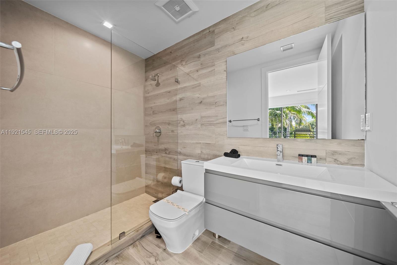 4740 Alton Road Miami Beach, FL 33140 - Photo 21 of 34 a bathroom with a toilet sink shower and mirror