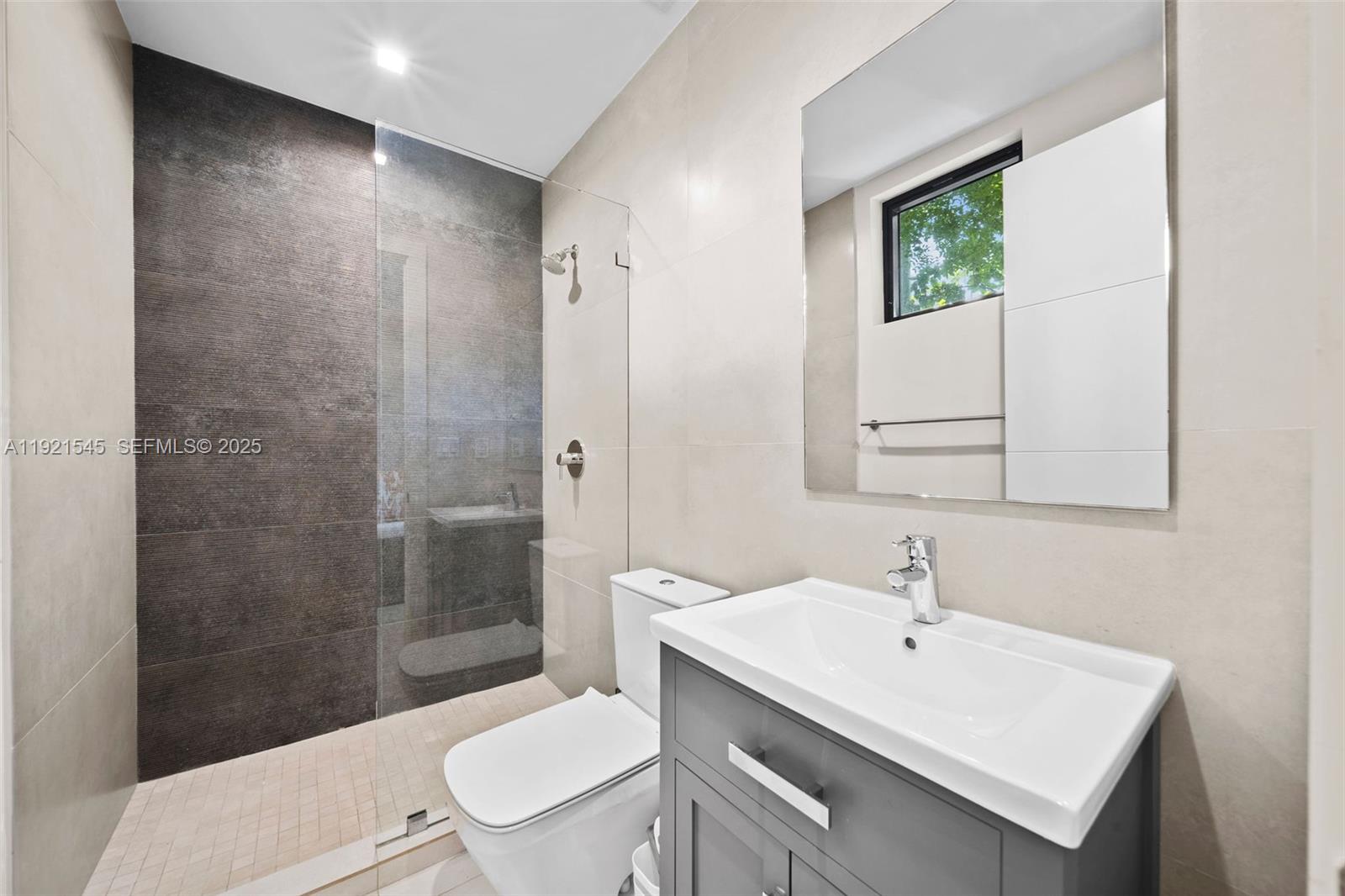 4740 Alton Road Miami Beach, FL 33140 - Photo 28 of 34 a bathroom with a sink toilet a mirror and shower