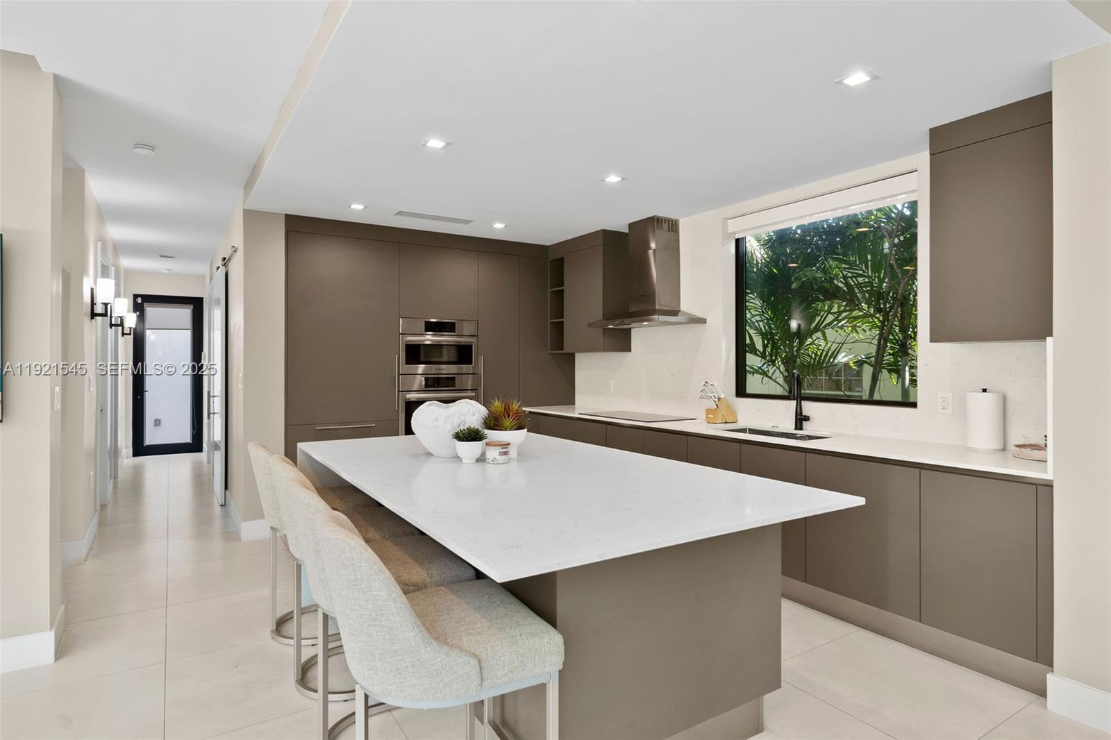 4740 Alton Road Miami Beach, FL 33140 - Photo 9 of 34 a kitchen with a sink a counter top space and appliances