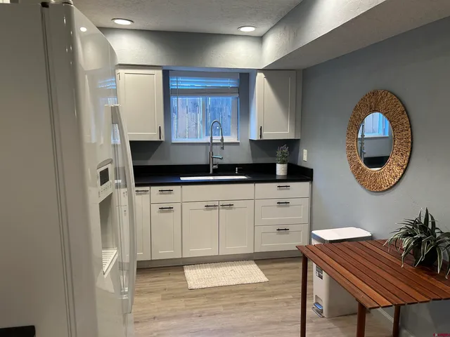 a kitchen with a refrigerator a sink and a stove with wooden cabinets