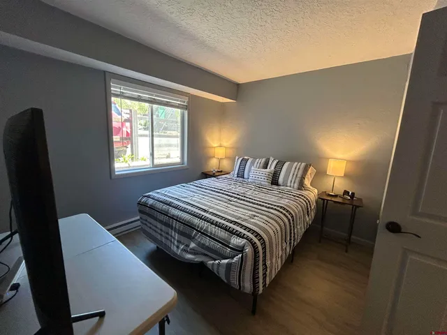 a bedroom with a bed two lamps and a large window