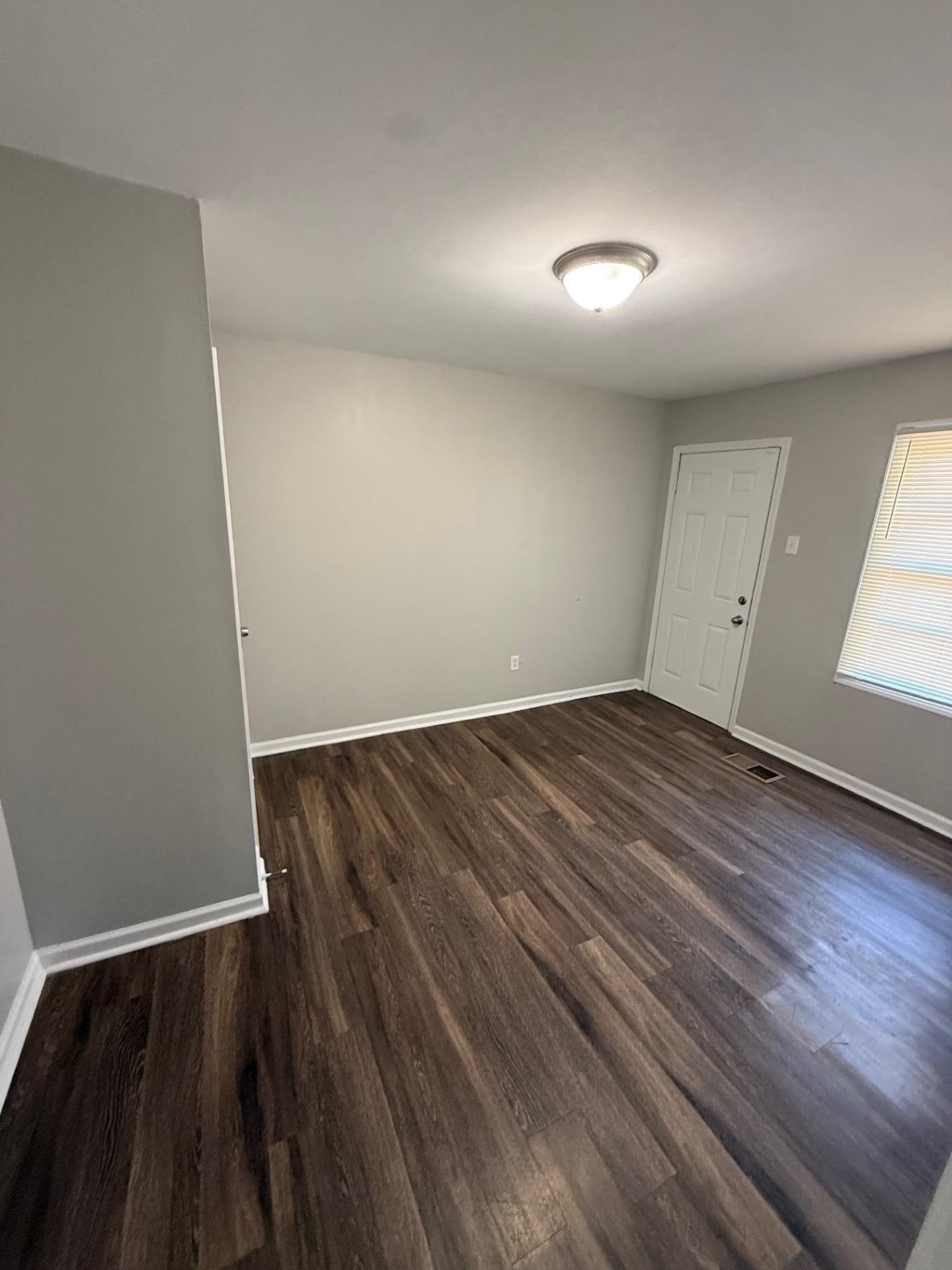 1560 Cane Road Memphis, TN 38106 - Photo 13 of 15 an empty room with wooden floor and windows