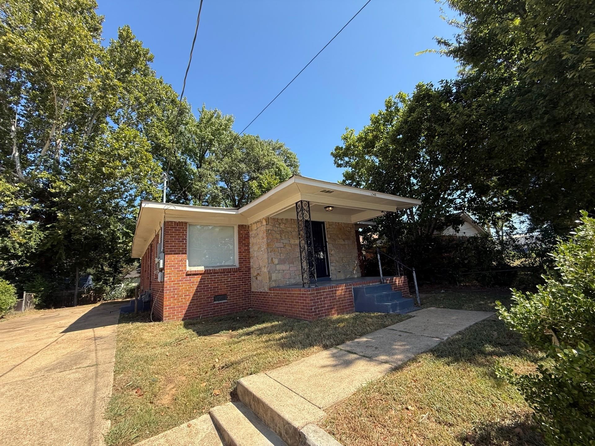1560 Cane Road Memphis, TN 38106 - Photo 2 of 15 a front view of a house with a yard and garage