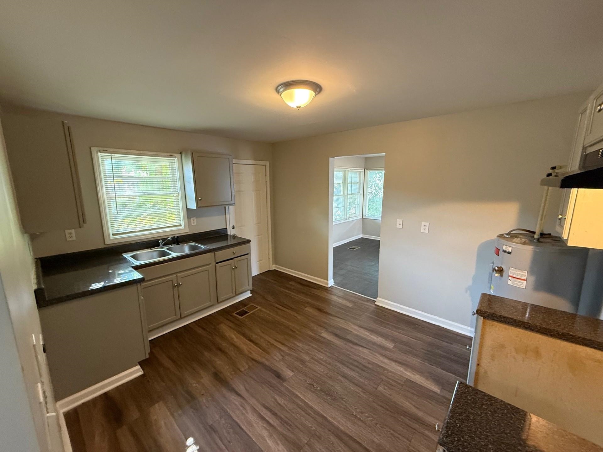 1560 Cane Road Memphis, TN 38106 - Photo 7 of 15 a kitchen with granite countertop a sink cabinets and wooden floor