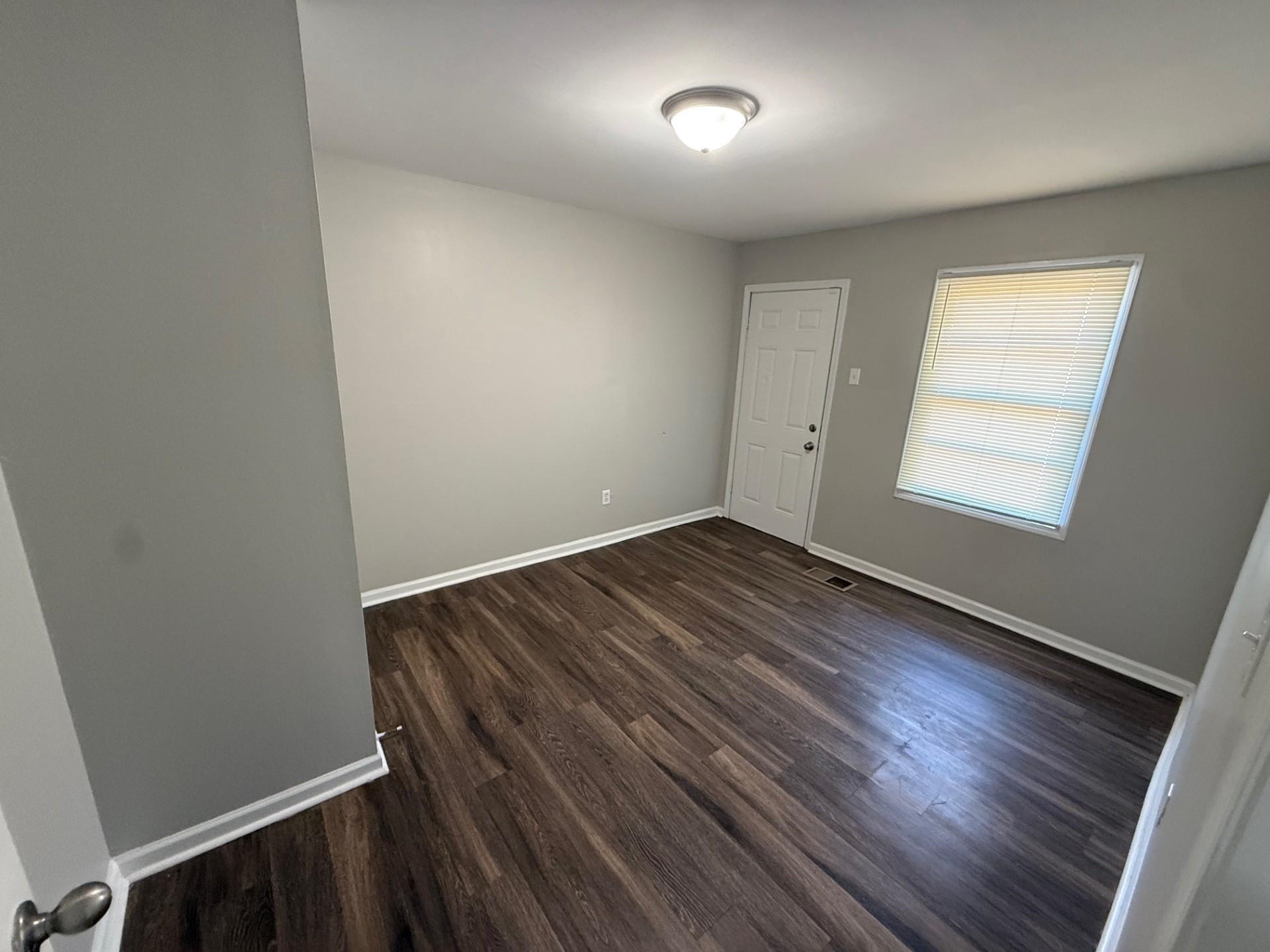 1560 Cane Road Memphis, TN 38106 - Photo 10 of 15 an empty room with wooden floor and windows