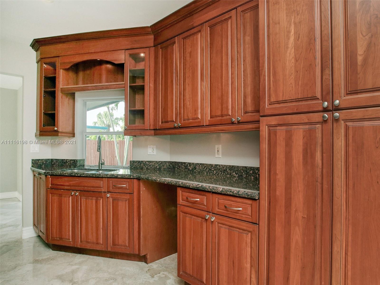49 Southwest 12th Avenue Boca Raton, FL 33486 - Photo 12 of 30 a kitchen with granite countertop wooden cabinets