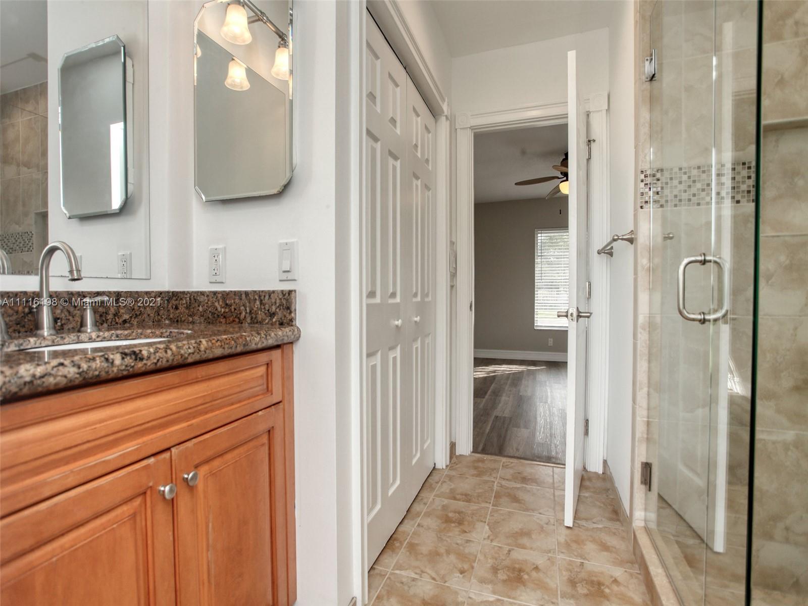 49 Southwest 12th Avenue Boca Raton, FL 33486 - Photo 16 of 30 a bathroom with a granite countertop shower sink and mirror