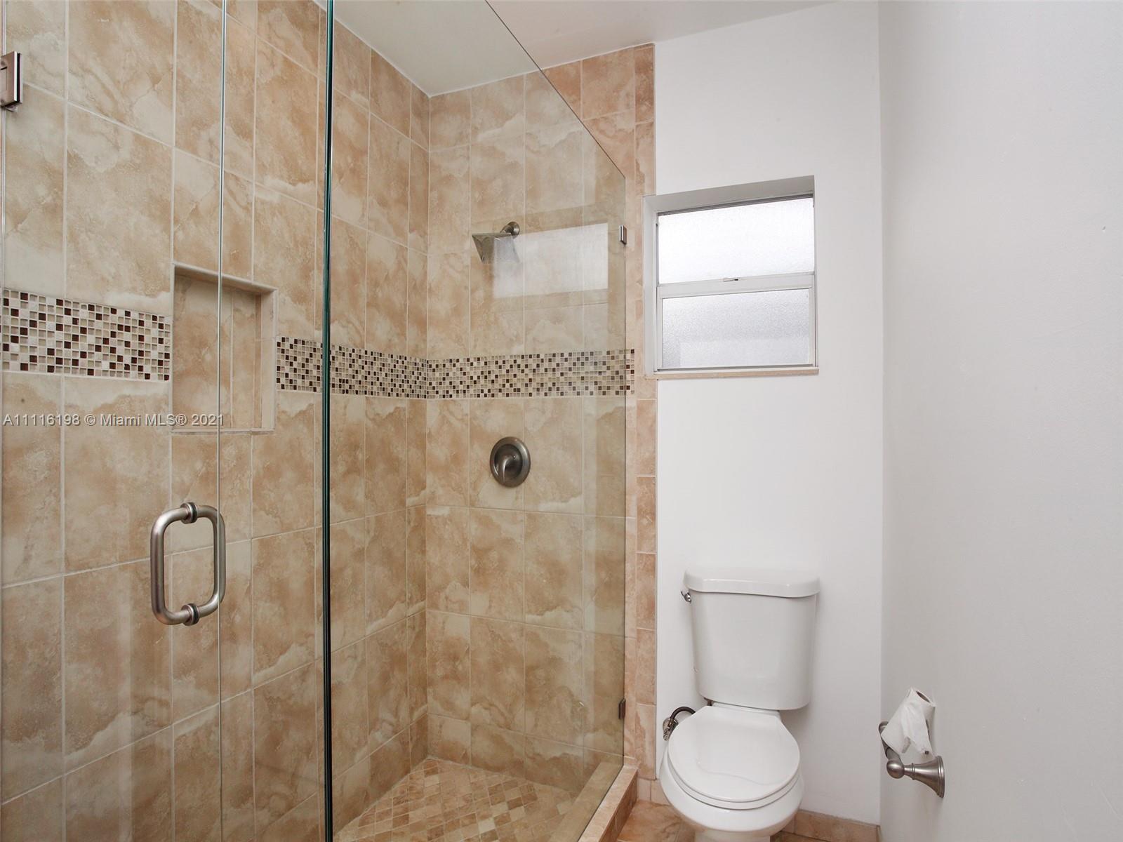 49 Southwest 12th Avenue Boca Raton, FL 33486 - Photo 17 of 30 a white toilet next to a bathroom shower