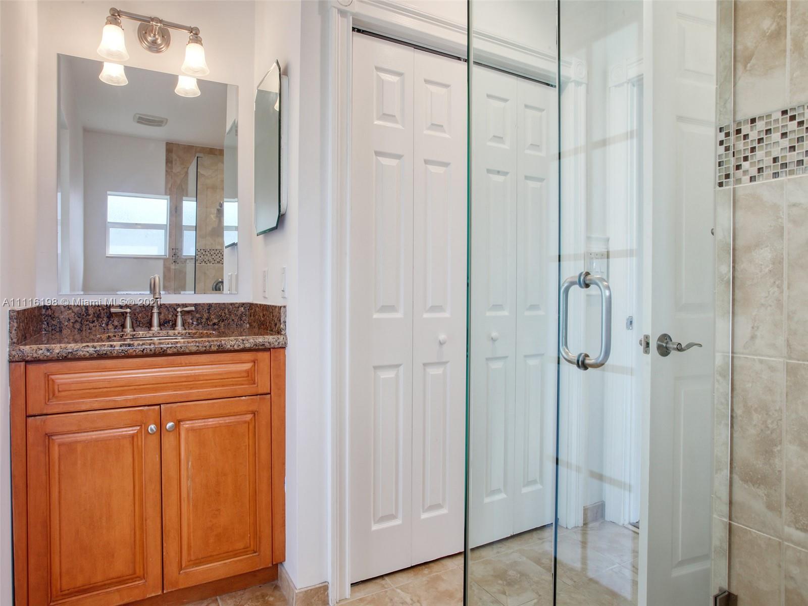 49 Southwest 12th Avenue Boca Raton, FL 33486 - Photo 18 of 30 a bathroom with a granite countertop sink two mirror and shower