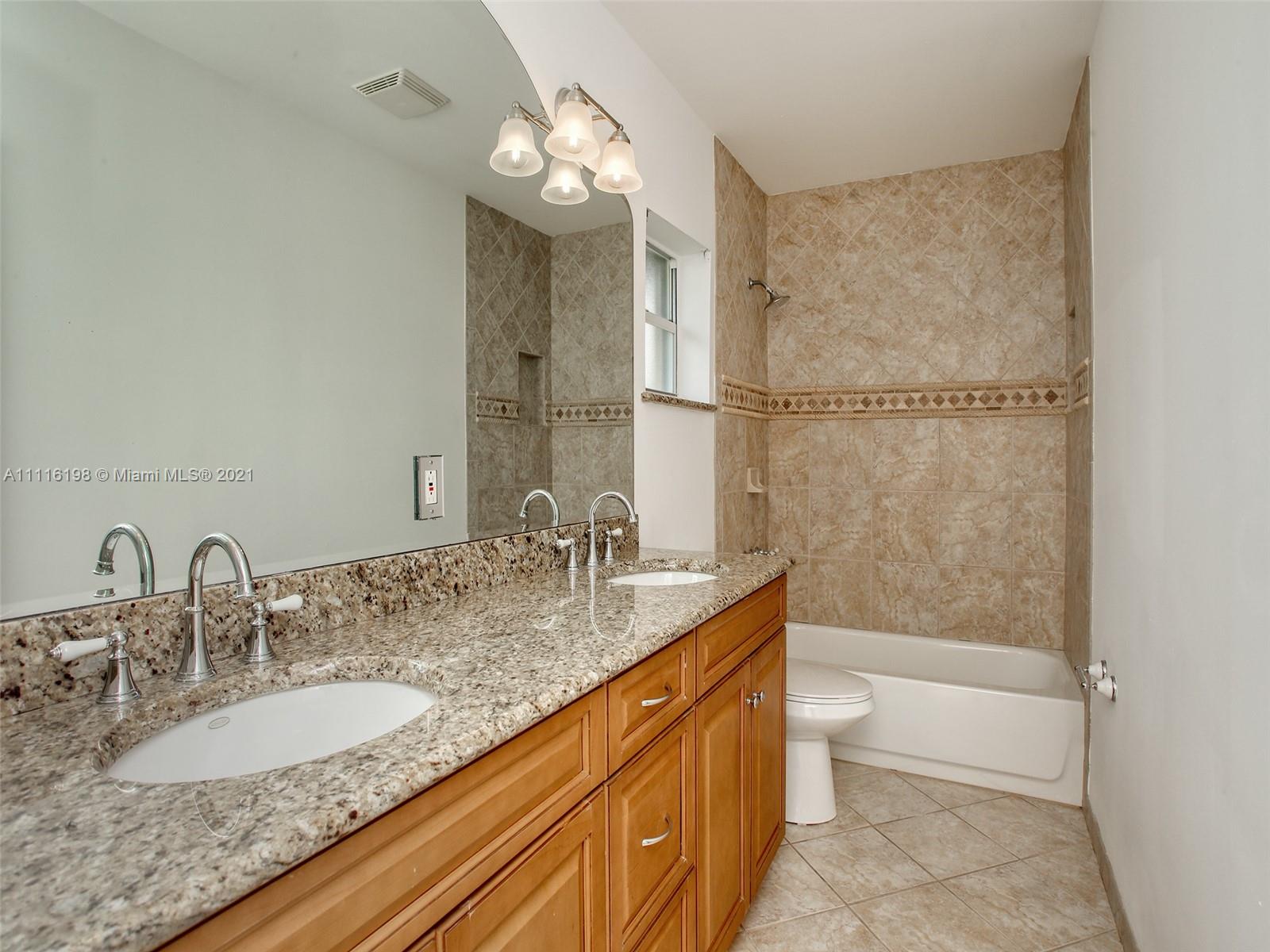 49 Southwest 12th Avenue Boca Raton, FL 33486 - Photo 24 of 30 a bathroom with a granite countertop sink a toilet and bathtub