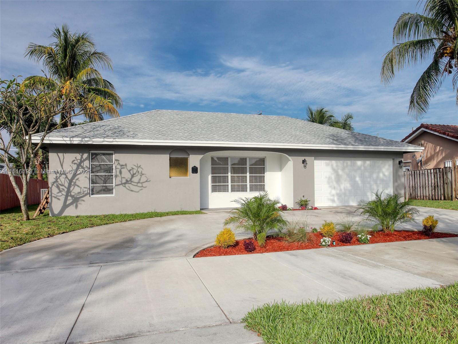 49 Southwest 12th Avenue Boca Raton, FL 33486 - Photo 3 of 30 a front view of a house with a garden and plants